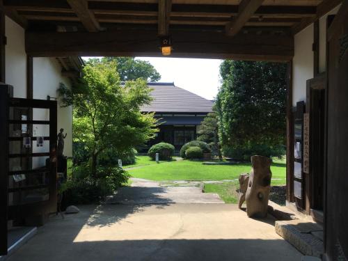an entrance to a building with a bear statue in the doorway at 貸切古民家別邸 in Tsukuba
