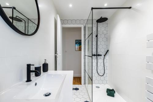 une salle de bain blanche avec une douche et un lavabo dans l'établissement L’Auguste - Appartement Terrasse, 450m de la plage, à Royan