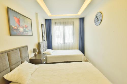 a bedroom with two beds and a clock on the wall at Апартаменты Best Home 26 Cleopatra Legacy in Alanya