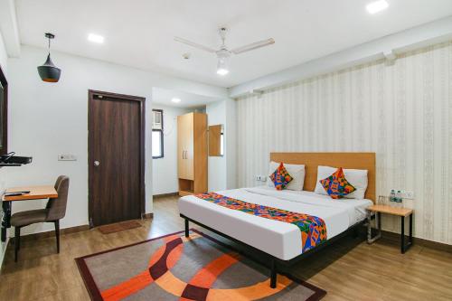 a bedroom with a bed and a desk and a chair at FabHotel Moro Rohini Sector 11 in New Delhi