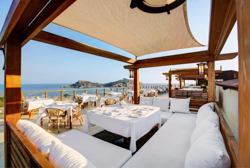 a restaurant with white tables and chairs and the ocean at TUI MAGIC LIFE Sarigerme in Sarigerme