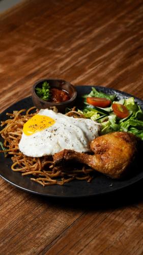 een bord eten met een gebakken ei en noedels bij La Nusa Penida Homestay by BIJAK in Nusa Penida
