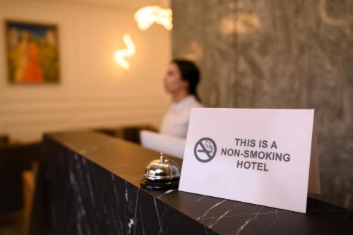 ein Schild, auf dem steht, dass dies jetzt ein Raucherhotel auf einer Theke ist in der Unterkunft Revive Boutique Hotel in Yerevan
