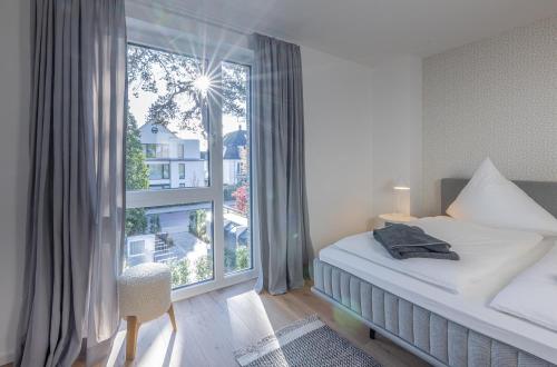 a bedroom with a bed and a large window at Strandglück in Timmendorfer Strand