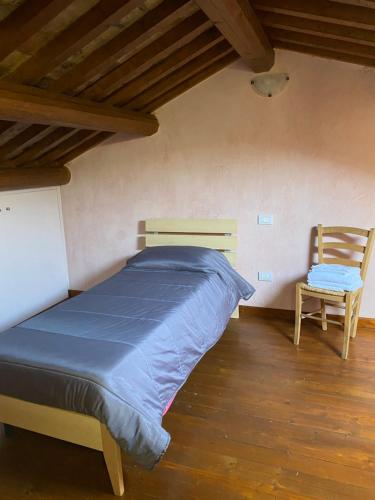 1 dormitorio con 1 cama y 1 silla en Il Belvedere sul Conero, en Potenza Picena