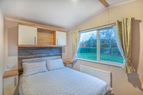 a bedroom with a bed and a large window at Luxury 8 Berth-Wheelchair Access in Port Seton