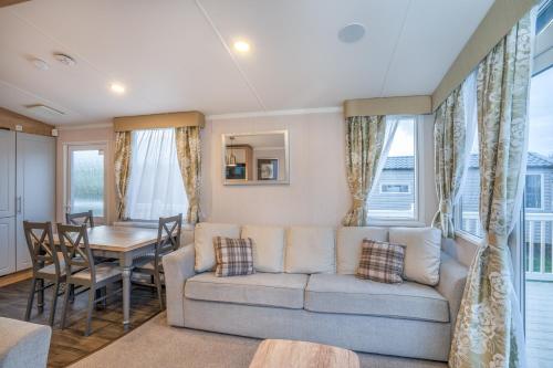 Luxury 8 Berth-Wheelchair Access في Port Seton: غرفة معيشة مع أريكة وطاولة