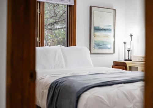 a bedroom with a white bed and a window at Enchanted Woods Hideaway in Kimberling City
