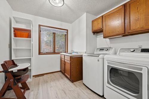 a small kitchen with a washer and dryer in it at Enchanted Woods Hideaway in Kimberling City