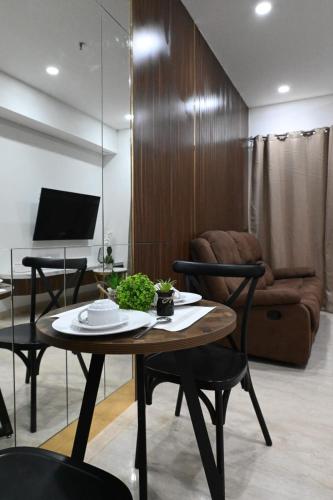 a living room with a table and a couch at Apartment Medan Podomoro City Deli by OLS Studio in Medan