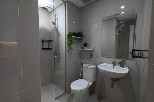 a bathroom with a toilet and a sink and a shower at Apartment Medan Podomoro City Deli by OLS Studio in Medan