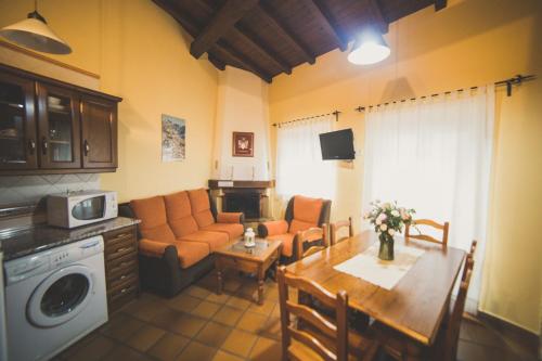 ein Wohnzimmer mit einem Sofa und einem Tisch in der Unterkunft Casa Rural Puerta del Sol II de 2 habitaciones in Candelario