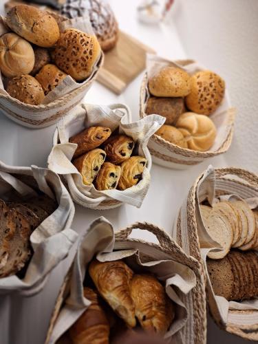 a table topped with baskets of different types of bread at Boutique Hotel Het Zoete Zijn in Borgloon
