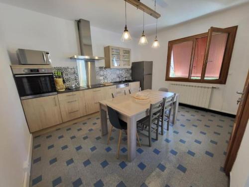 eine Küche mit einem Tisch und Stühlen im Zimmer in der Unterkunft Le Cèdre in Les Vans