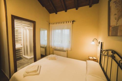 a bedroom with a white bed and a window at Casa Rural Puerta del Sol II de 2 habitaciones in Candelario