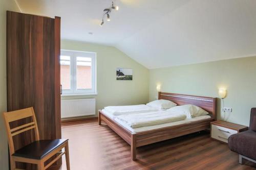 SahrensdorfにあるBuedlfarm-NordOstのベッドルーム1室(ベッド1台、テーブル、椅子付)