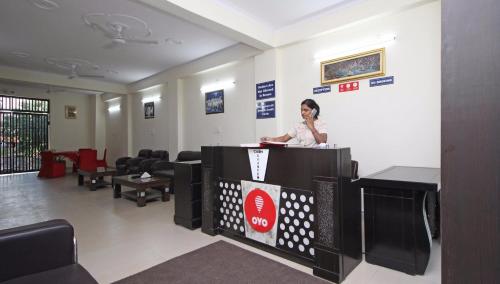 a woman standing at a podium in a waiting room at OYO Surya Palace in New Delhi