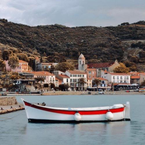 a boat in the water with a town in the background at Vue exceptionnelle sur la baie de Collioure in Collioure