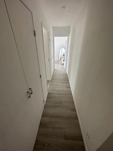 a hallway with white doors and a wooden floor at T3 Moulin à vent proche UPVD in Perpignan