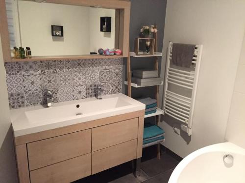 une salle de bain avec un lavabo et un miroir dans l'établissement Maison de charme, à Saint-Avé