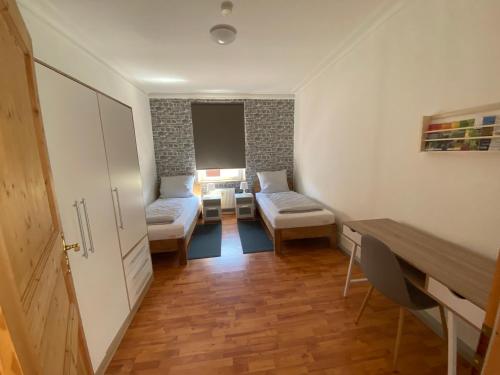 a small room with two beds and a desk at Ferienwohnung „Lochbach“ in Bad Mergentheim