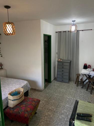 1 dormitorio con cama, tocador y mesa en Suíte Pontal, en Arraial do Cabo