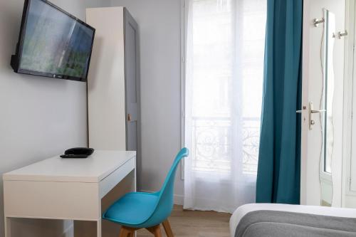 Cette chambre comprend un bureau et une chaise bleue. dans l'établissement Paris Legendre, à Paris