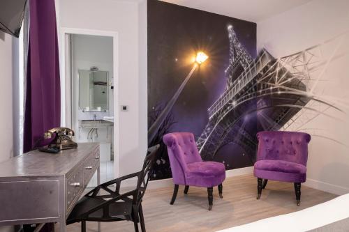 - deux chaises violettes et un bureau dans une chambre dans l'établissement Paris Legendre, à Paris