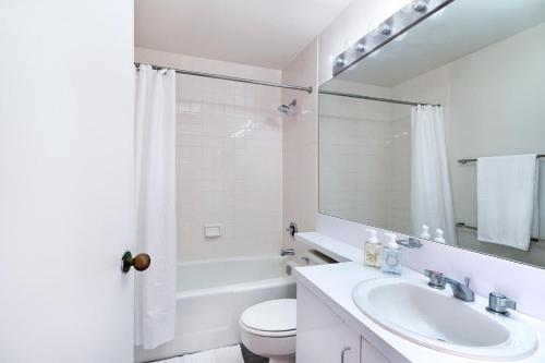 a white bathroom with a sink and a toilet at Beautiful 1 BR Apartment in Columbus Avenue in New York