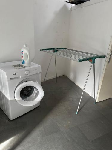 una lavadora y una mesa en una habitación en CHEZ COCO ET HERVE rez-de-chaussée, en Sigean