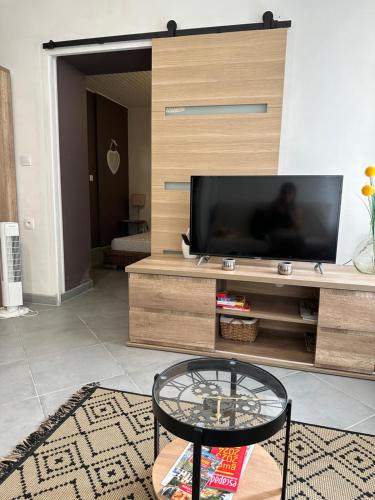 un salon avec une télévision et une table en verre dans l'établissement CHEZ COCO ET HERVE rez-de-chaussée, à Sigean