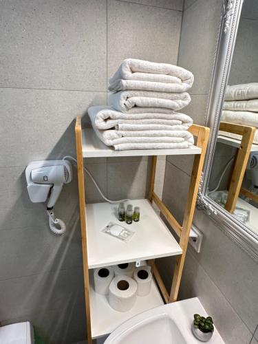 a bathroom with a shelf with towels and a toilet at Cozy Luxury Apartments - Coresi Mall #Brasov in Braşov