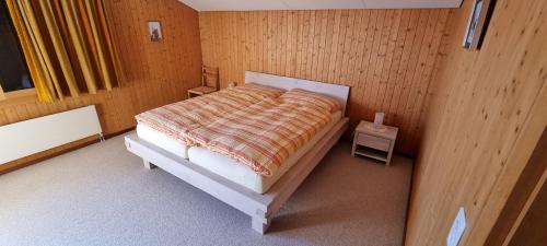 a bedroom with a bed in a wooden room at Casa Bereca in Flims