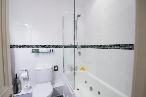 a white bathroom with a shower and a toilet at Chateau La Chaire in Rozel