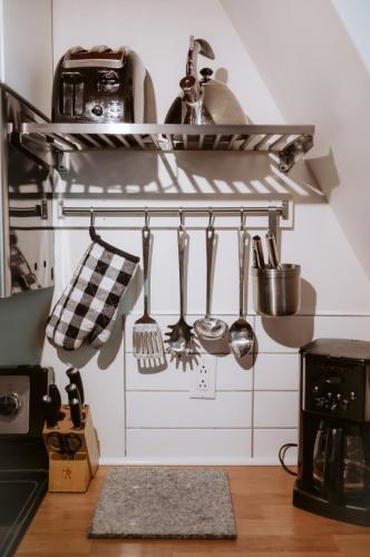 a kitchen with lots of utensils on a shelf at Le Grizzli Orford in Orford