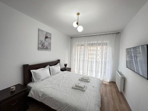a bedroom with a bed with two towels on it at Cozy Luxury Apartments - Coresi Mall #Brasov in Braşov