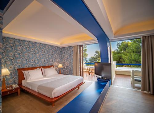 A bed or beds in a room at Ramada Loutraki Poseidon Resort