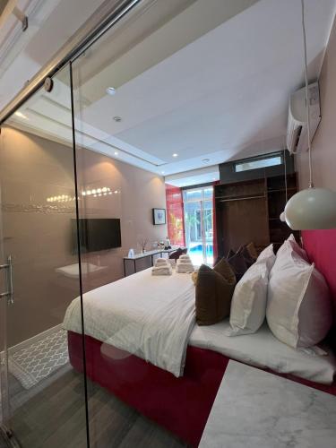 a bedroom with a large bed with a glass wall at Hill Valley Asilah - Luxury Living & Boutique Hotel in Asilah