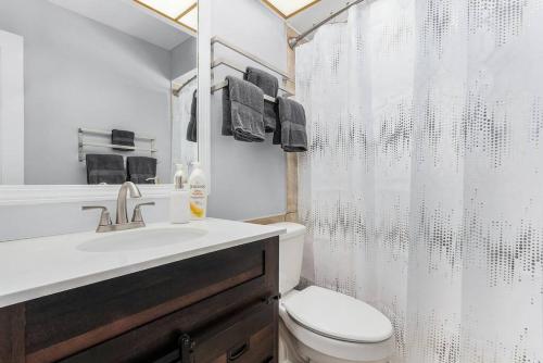 uma casa de banho com um WC e uma cortina de chuveiro em Charming Family Retreat Heated Pool Private Yard em Cape Coral