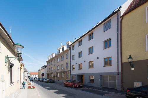 una calle con edificios y coches estacionados en la calle en Schickes All-inklusive Apartmentzimmer by RESIDA Asset GmbH, en Brunn am Gebirge