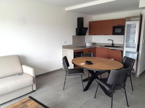 a kitchen and dining room with a table and chairs at Domaine d'Arca Flaubert 20 T2 4 pers in Porto-Vecchio