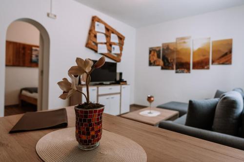 a vase with a plant on a table in a living room at Hotel Garni Familie Gruber in Spital am Pyhrn