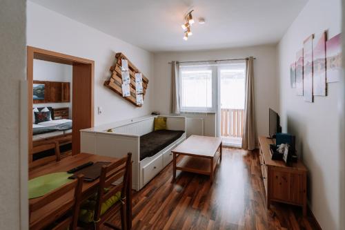 a bedroom with a bed and a table and a window at Hotel Garni Familie Gruber in Spital am Pyhrn