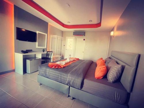 a bedroom with a bed with orange pillows on it at เสาวลักษณ์ เรสซิเด้นท์ in Khon Kaen