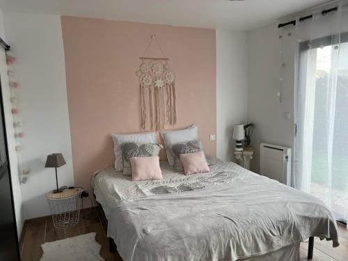 1 dormitorio con 1 cama grande con almohadas rosas en Quiniere - Entre Lac et Forêt, en Blois