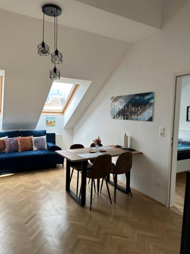 sala de estar con mesa y sofá en Dachgeschoss City Apartment in Zentrum Wiens en Viena