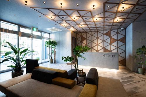 a lobby with a couch and potted plants in a building at R Hotel Namba South in Osaka