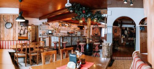 シュピタル・アム・ピュールンにあるGasthof Familie Gruber Hotel-Pensionのテーブルと椅子のあるレストラン、バー