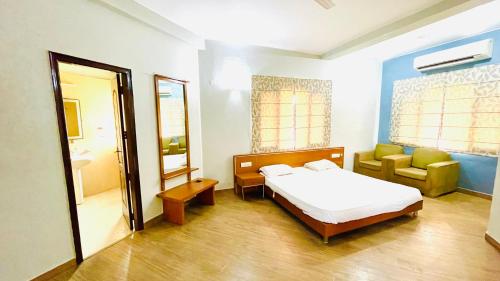 a bedroom with a bed and a chair and a mirror at Red orchid farm in Gurgaon