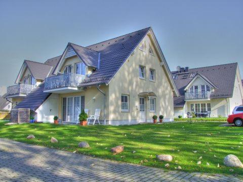 una grande casa con una macchina parcheggiata di fronte di Familienurlaub Natur- & Zentrumsnah im Granitzhof App 03 a Binz